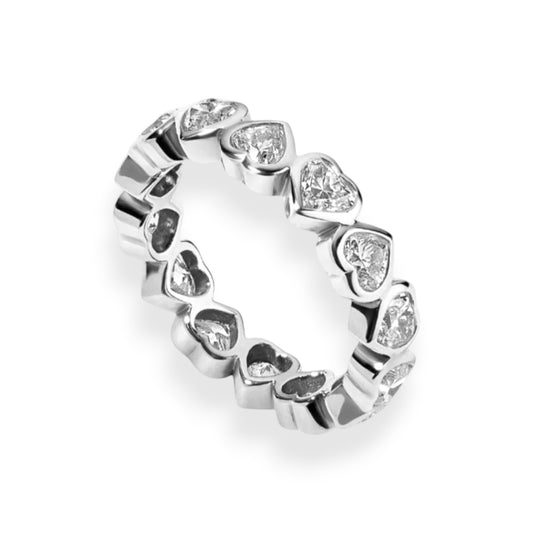 Silver ring with heart-shaped gemstones on a white background. Heart cut moissanite eternity band in yellow gold bezel setting