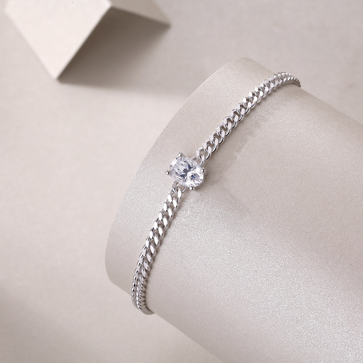 Silver bracelet with a central gemstone on a light gray background