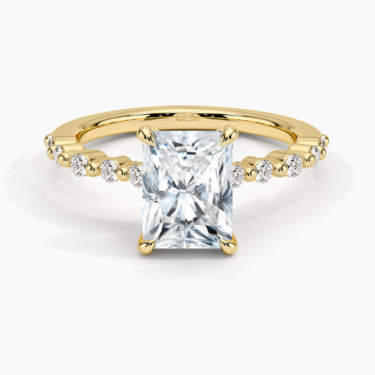 Gold ring with a large diamond and smaller diamonds on the band against a white background