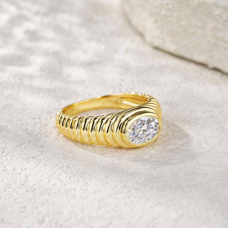 Gold ring with a diamond on a light fabric background