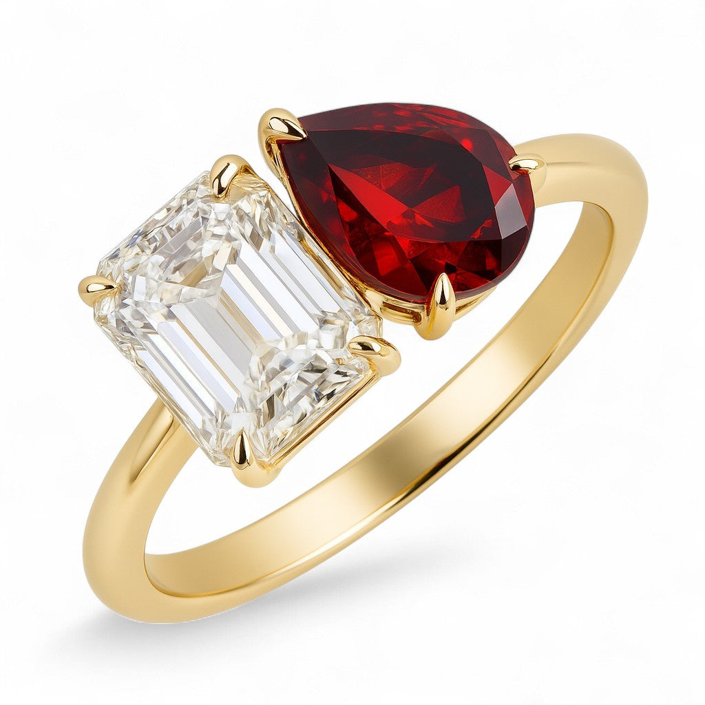 Gold ring with a red gemstone and a clear gemstone on a white background