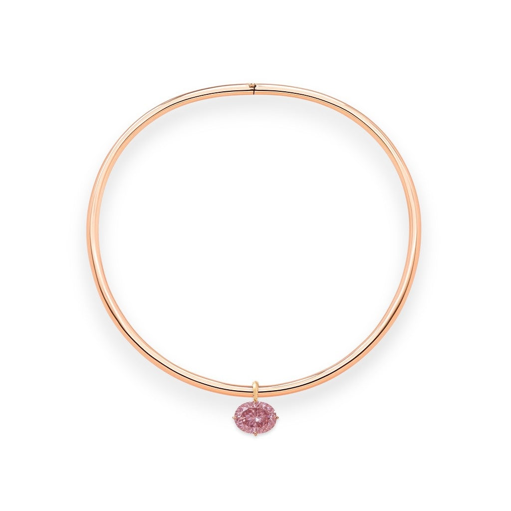 Rose gold torque necklace with a pink diamond on a white background