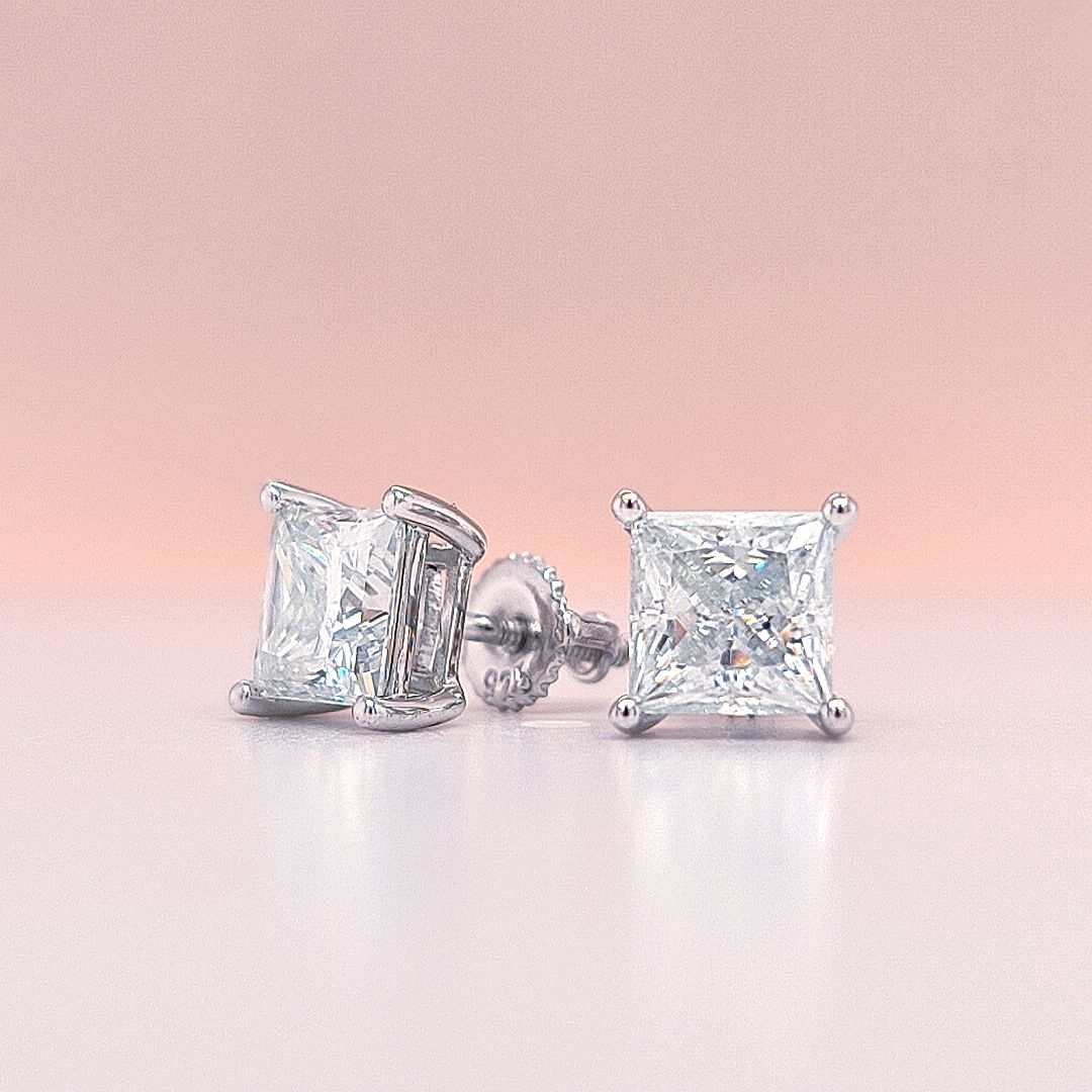 14K Gold earrings with clear princess cut moissanite diamond gemstones on a white background