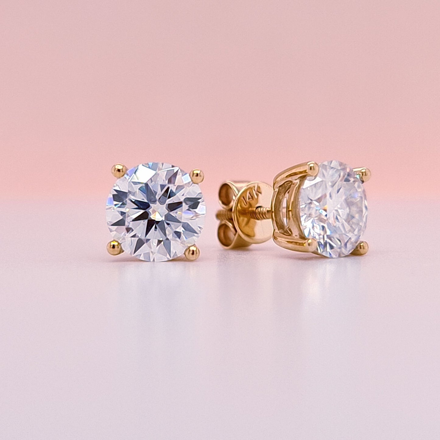 14K Gold stud earrings with clear moissanite diamond gemstones on a white background