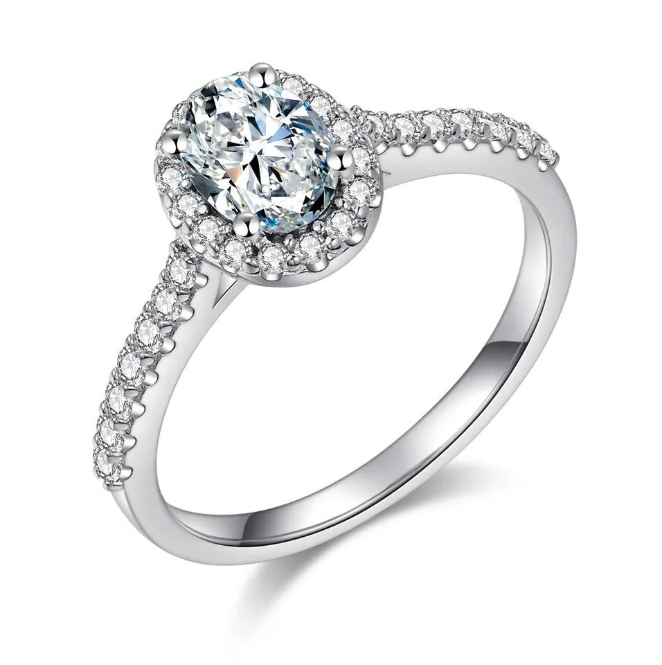 A 1 carat oval cut halo ring with a half pave band, set in a white gold band.