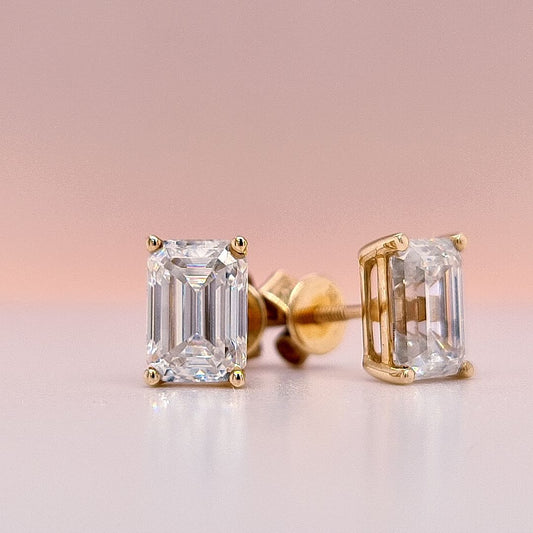 Gold emerald-cut moissanite diamond earrings on a white background