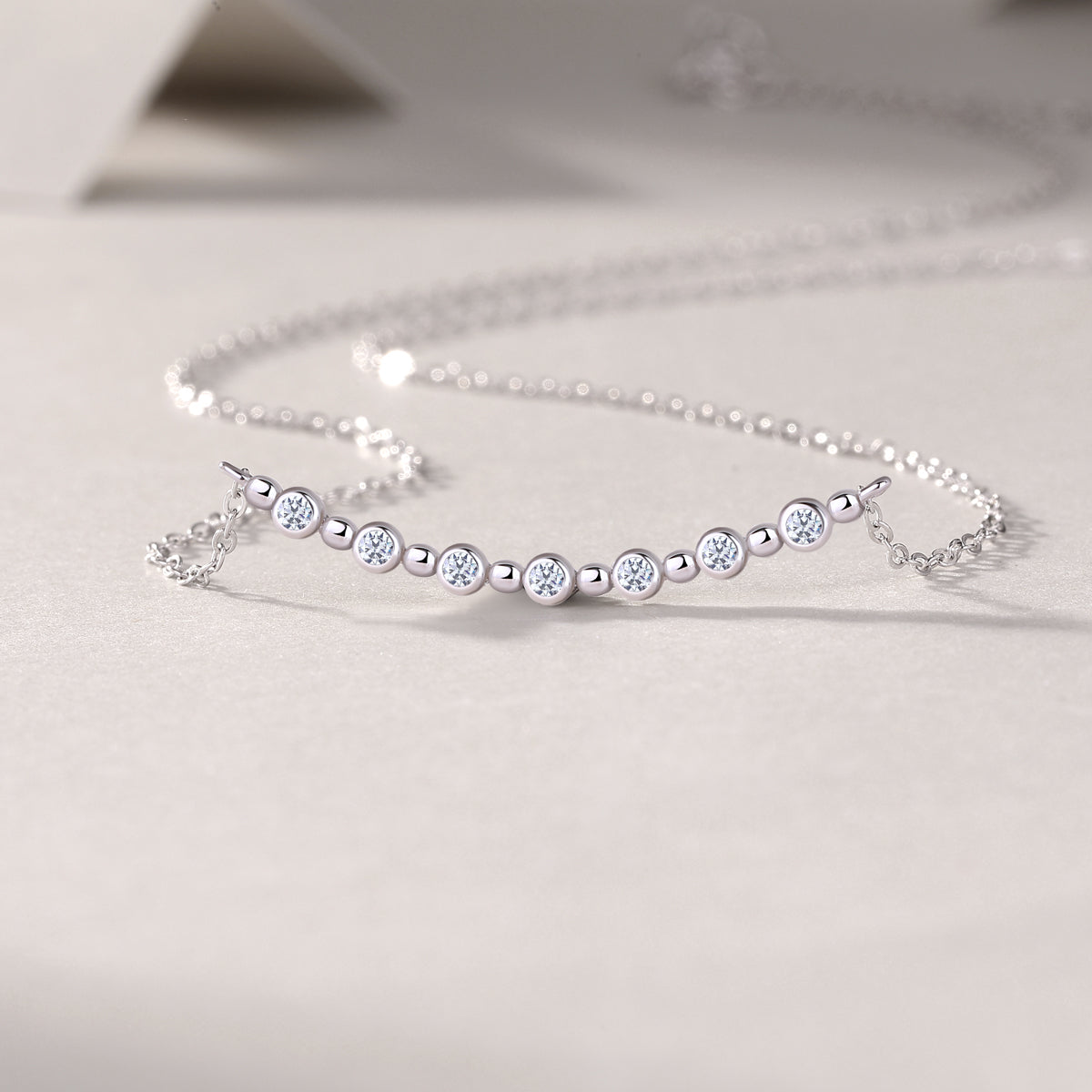 Silver bracelet with small diamonds on a light gray background