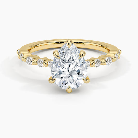 Gold ring with a large diamond and smaller diamonds on the band against a white background. Pear Cut Accent Band Moissanite Ring
