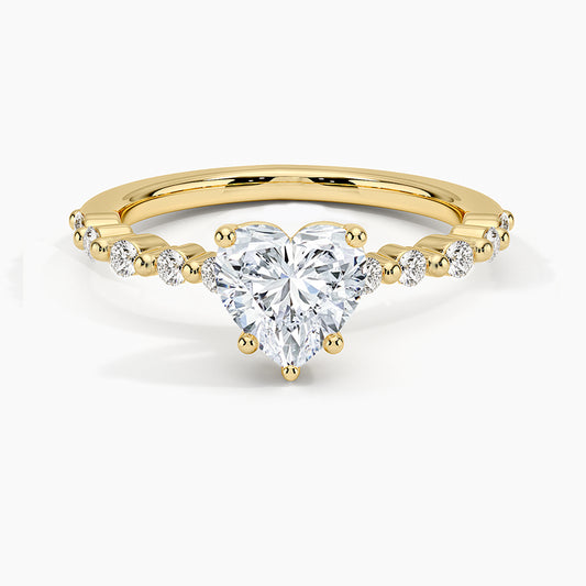 Gold ring with a heart-shaped diamond on a white background