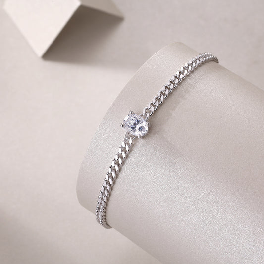Silver bracelet with a central gemstone on a light gray background