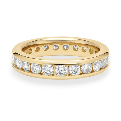 Gold ring with embedded diamonds on a white background. Classic 18K yellow gold eternity band with channel-set moissanite. Sleek, secure, and endlessly elegant.